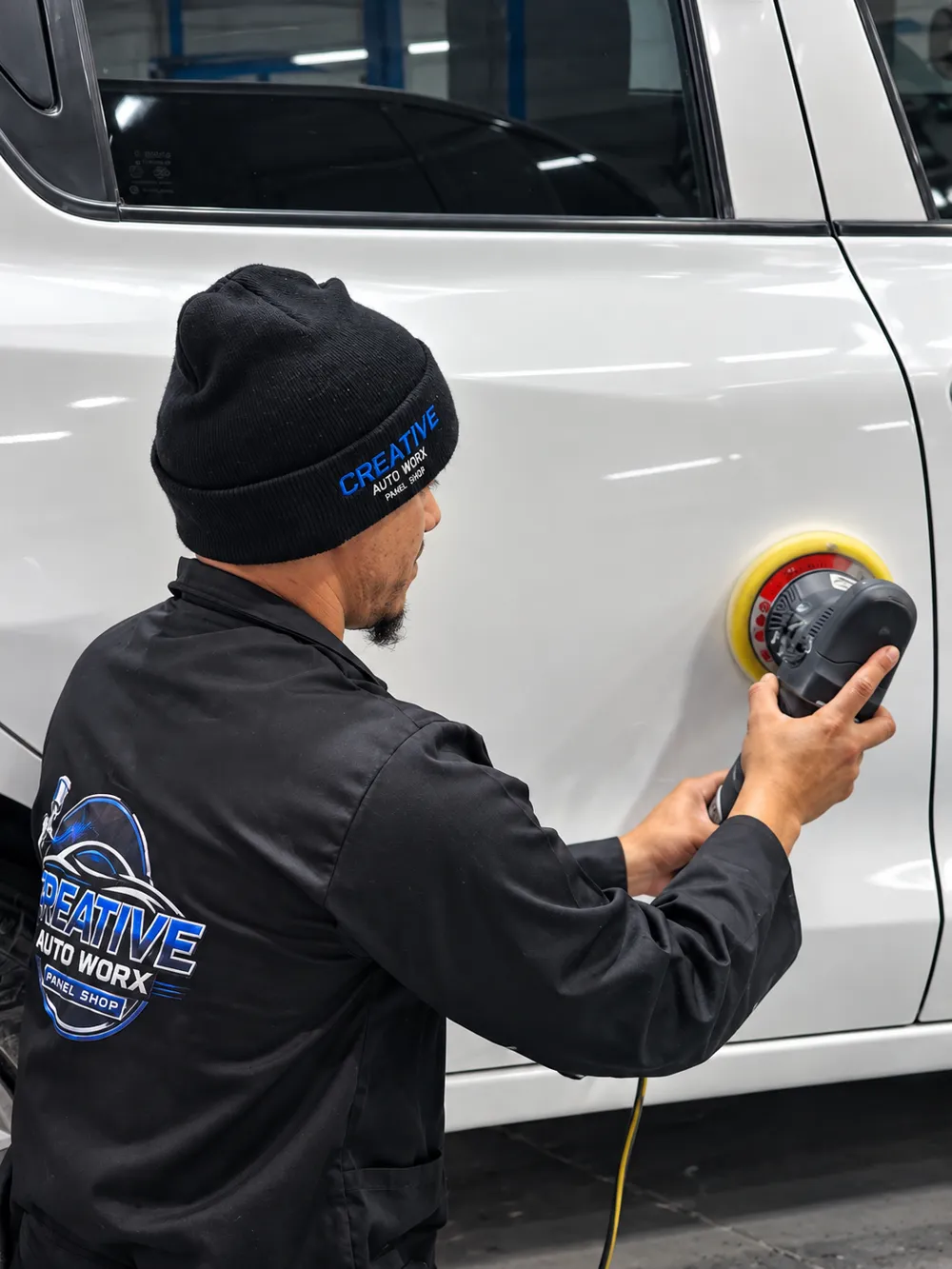 Creative Auto Worx technician polishing a repaired vehicle panel